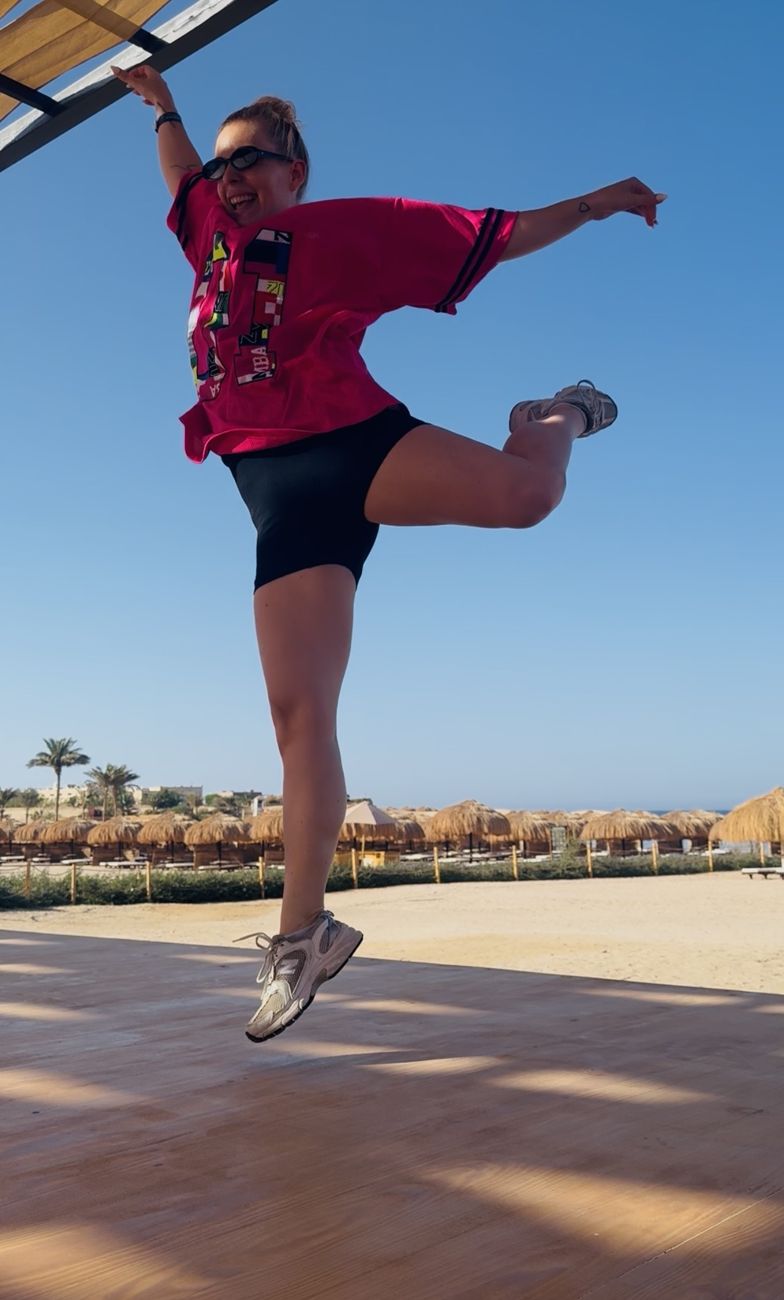 Lisa springt auf einer Tanzfläche am Strand